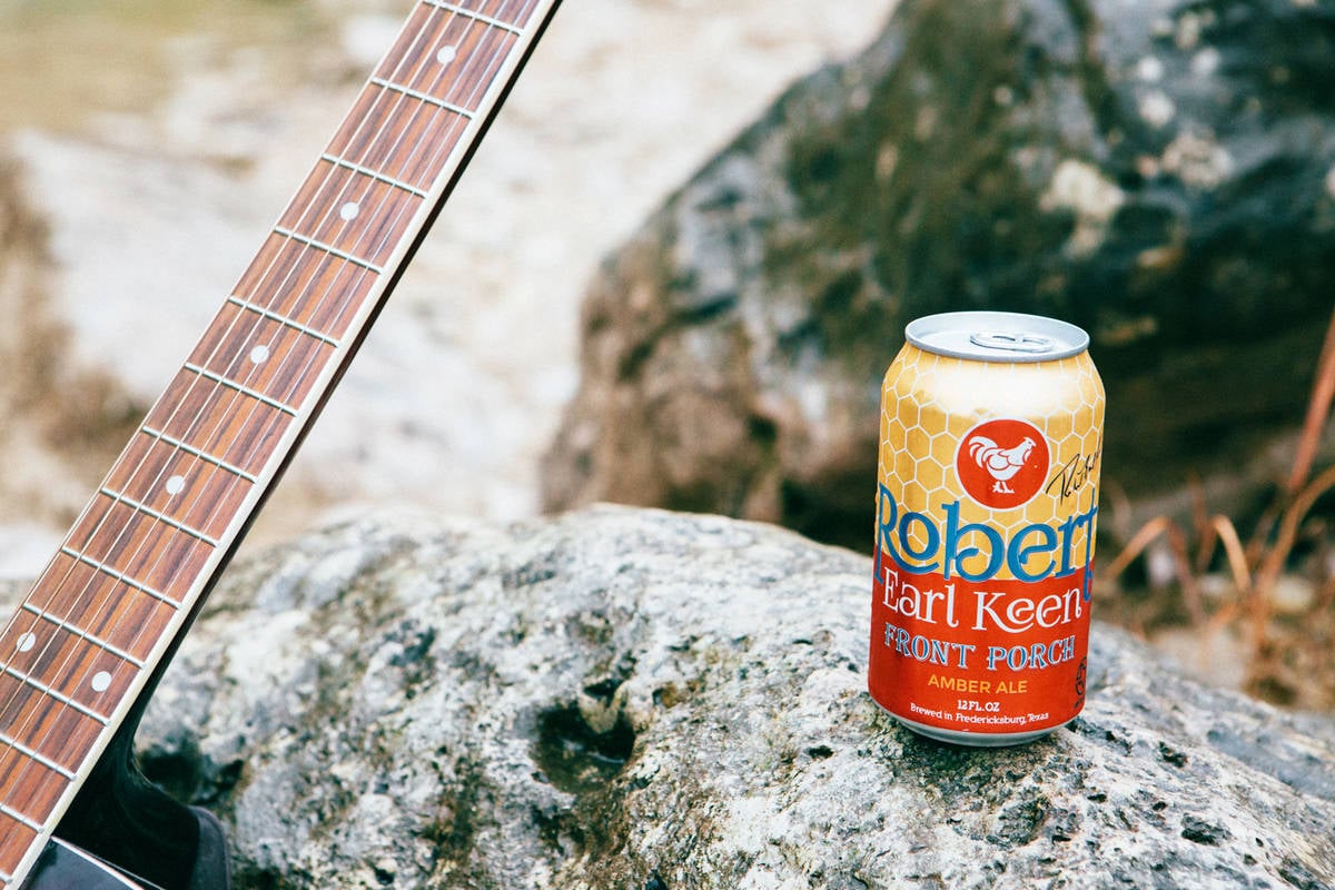 pedernales brewing co. robert earl keen series beer sits next to a guitar