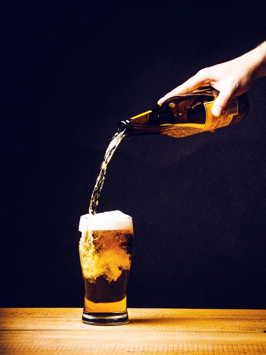 person pouring beer from a great height