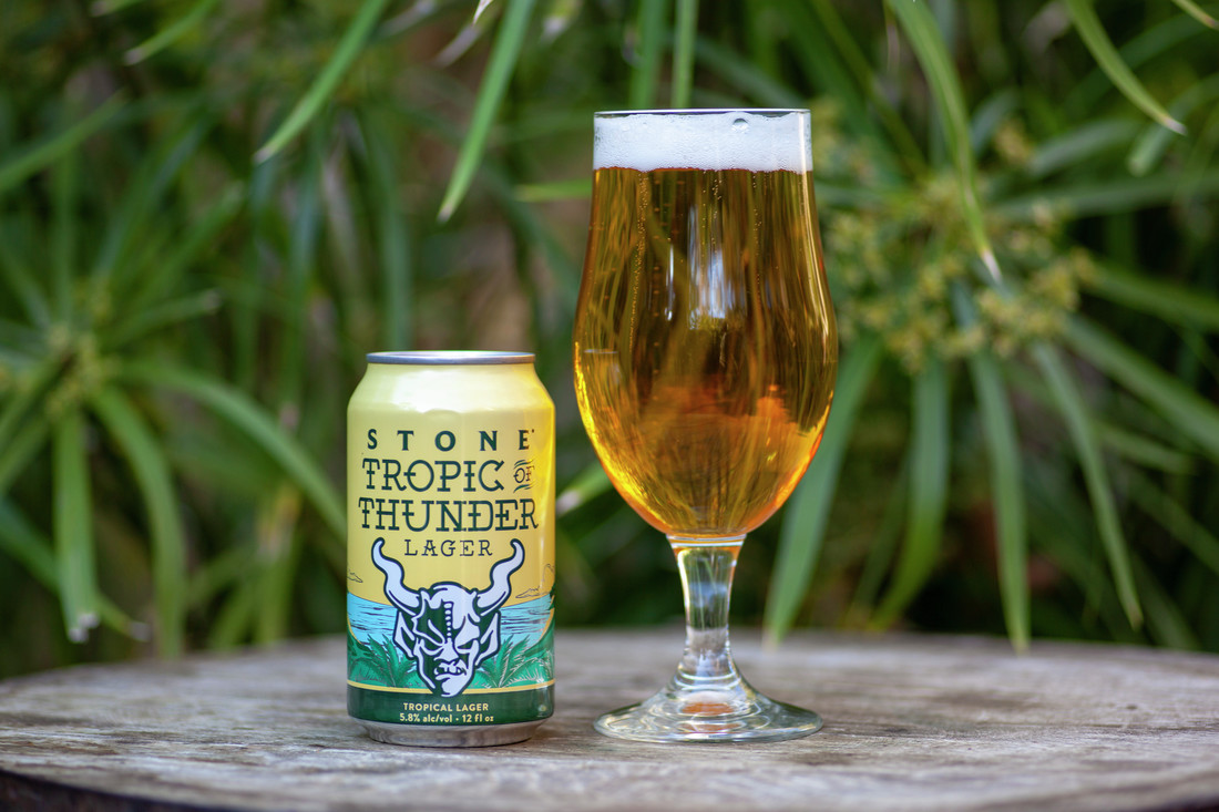 A can and poured glass of Tropic Thunder Lager by Stone Brewing Co.